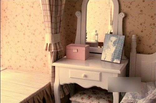 白色木质的欧式梳妆台，在卧床旁边，代替了一个床头柜。